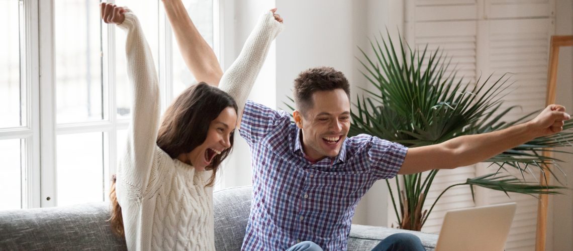 Excited Man And Woman Screaming With Joy Raising Hands Looking A