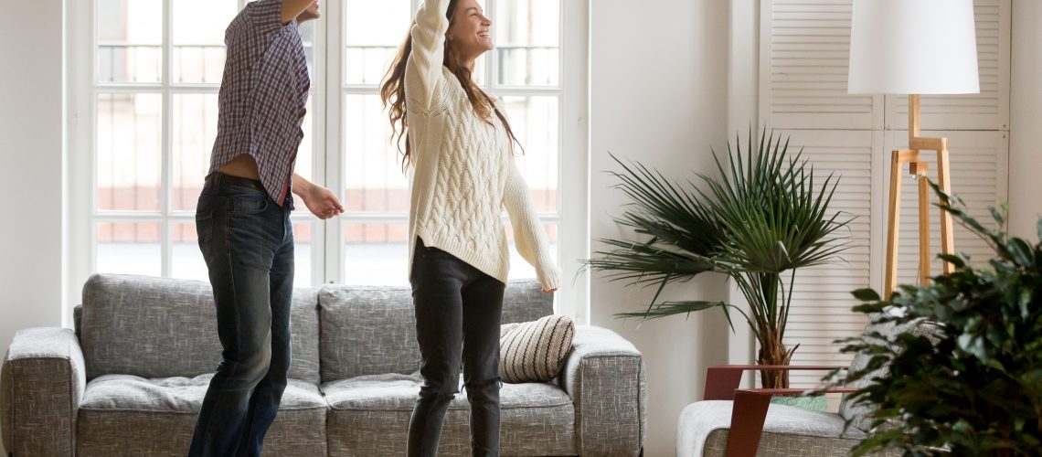 Happy Romantic Couple Having Fun In New Home, Man Holding Womans